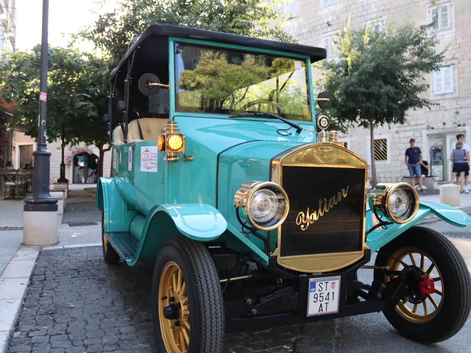 Oldtimer iz 3/4 sprijeda, mjedena maska i žbicani kotači